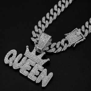 Detail of silver Cuban chain necklace with iced-out QUEEN crown pendant and zircons