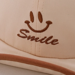 Chapeau de soleil bébé en coton crème avec broderie Smile marron et bordure roulée