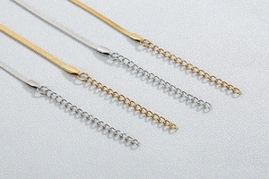 Détail de colliers minimalistes en maille serpent dorée et argentée avec rallonges fines