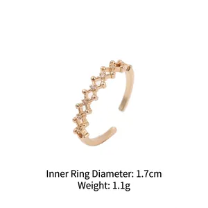 Gold plated open ring with geometric hollow design and zircon accents on white background