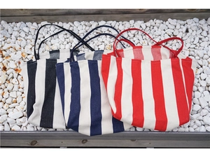 Detailed close-up of large capacity striped canvas tote bags in black, blue, and red colors