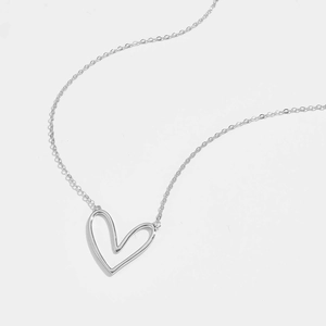 Detailed macro view of the silver heart hollow pendant and minimalist chain texture