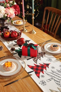Detailed close-up of Christmas table runner with red buffalo plaid and leopard print trees
