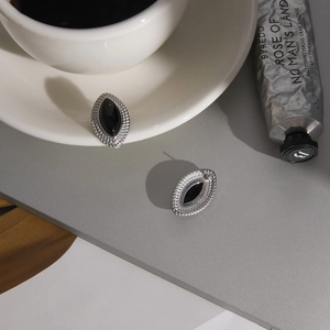 Macro view of vintage oval black onyx earrings with twisted silver rope texture