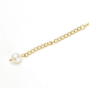 Detail of 18K gold stainless steel anklet showing white pearl and tassel chain texture