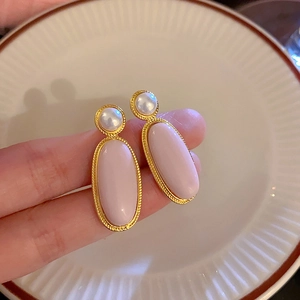 Dettaglio orecchini a fiore con opale rosa, bordi in oro intrecciato e perle bianche