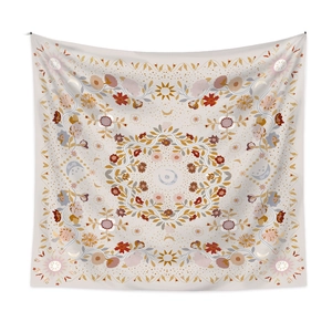 Detailed view of bohemian floral tapestry with sun and moon celestial motifs