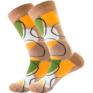 Detail of colorful knitted crew socks featuring abstract orange and green color blocks