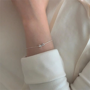 Elegant 925 sterling silver bow knot bracelet on a female wrist with a minimalist design