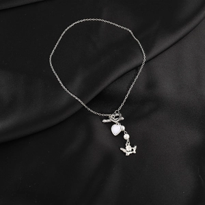 Detail of silver OT clasp necklace with heart pendant, white pearls and butterfly charm