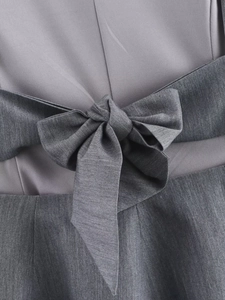 Vue détaillée du haut gris avec un nœud papillon élégant et la texture du tissu
