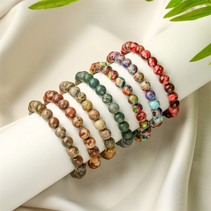 Five assorted 8mm natural tiger eye and lava stone elastic beaded bracelets on display