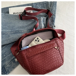 Detail view of burgundy woven belt bag showing interior space for a smartphone