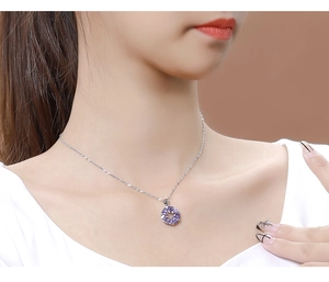 Detailed close-up of a 925 silver necklace with a purple zircon pendant on a model's neck