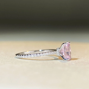 Macro detail of a 2-carat pink rectangular gemstone set in a silver pave-set diamond ring