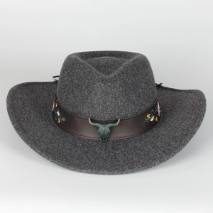 Detail of grey felt fedora featuring a leather band with floral embroidery and bull skull charm