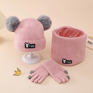 Detailed knit texture of pink winter set with cartoon rabbit label and pom-poms