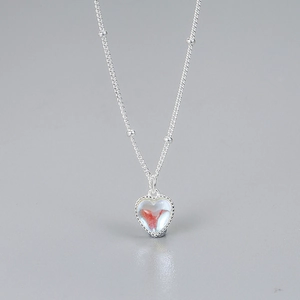 Macro detail of S925 silver necklace featuring a translucent heart pendant on a fine chain