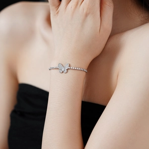 Détail du bracelet de tennis papillon en zircon argenté porté au poignet pour un look chic