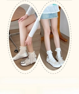Close-up of white lace ruffle socks with bow detail and silver Mary Jane shoes