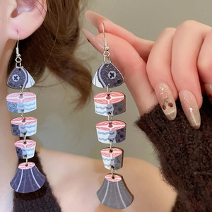 Artistic segmented fish dangle earring with vintage wood print and tassel finish