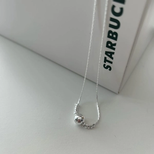 Close-up of a 925 sterling silver beaded necklace featuring a polished center ball charm