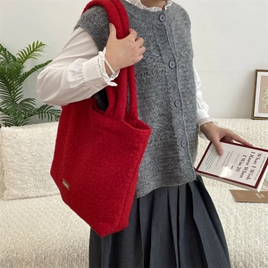 Dettaglio della borsa tote in pile rosso con grande capacità e finitura in morbido tessuto