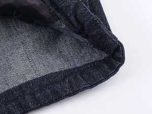 Makroansicht von dunklem Indigo-Denim mit präzisen Nähten und Köperbindungstextur