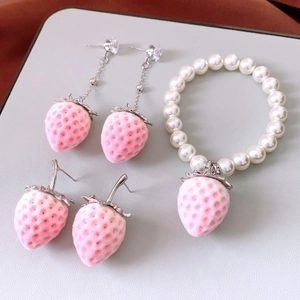 Macro view of sweet flocked strawberry pendant jewelry set including bracelet and earrings