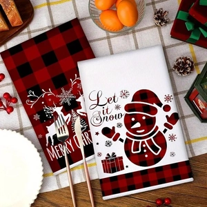 Close-up of festive Christmas kitchen towels with reindeer and snowman prints on wooden table