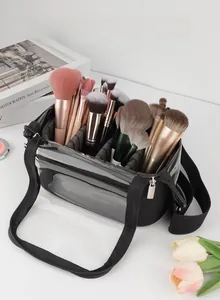 Macro shot of a clear makeup brush bag with black nylon trim and adjustable shoulder strap