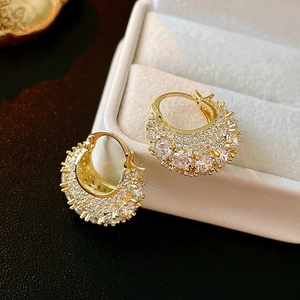 Detailed view of luxury gold-plated handbag-shaped earrings with white zircon accents