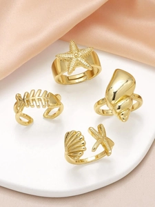 Detailed view of four gold ocean-themed adjustable rings with starfish and seashell designs