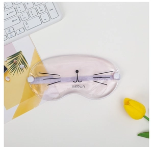 Detail view of purple cat-themed gel eye mask with meow design on a white desk