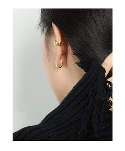 Detailed close-up of gold minimalist geometric double hoop ear cuff and U-shaped earrings