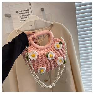 Pink hand-woven shell bag with white daisy flowers and elegant pearl chain strap