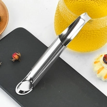 Macro view of silver 304 stainless steel tea infuser spoon on a textured black stone tray