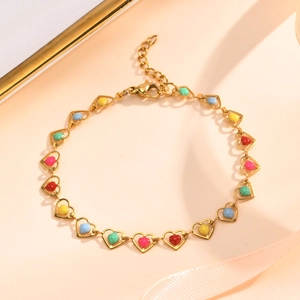 Detailed macro of gold heart chain links with colorful enamel inlay and lobster clasp