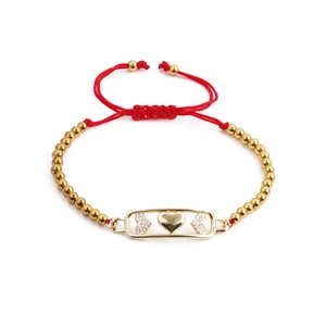 Zirconia heart charm bracelet with gold-plated metal plate on adjustable red woven rope