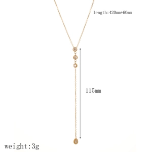 Vue détaillée du collier en Y doré avec pendentif incrusté de cristaux et design à glands