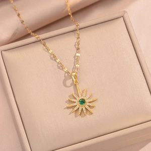 Elegant gold starburst necklace with a green center gemstone and white zircon accents