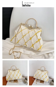 Detail of tweed shell bag with pearl clasp and golden metal handle in white and yellow