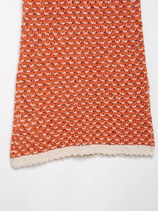 Macro detail of multicolored crochet knit mini dress showing scalloped hem and texture