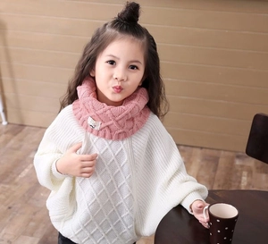 Detailed view of pink knitted knit snood scarf with argyle pattern on a young girl