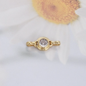 Macro detail of gold-plated circular zircon connector for minimalist jewelry DIY