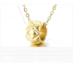 Macro shot of gold-toned ring pendant with classic diamond quilted texture and steel chain