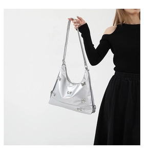 Detailed view of silver shoulder bag with 3D butterfly motifs shown on model
