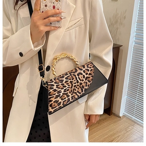Detail view of leopard print crossbody bag featuring a woven gold rope handle and black strap