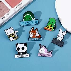 Close-up of colorful enamel animal brooches with fun slogans on light blue background