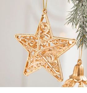 Close-up of golden hollow star ornament with intricate vine patterns on a Christmas tree